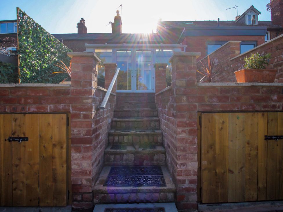 A garden with stairs leading to a glass door at Riverside Cottage in Shrewsbury