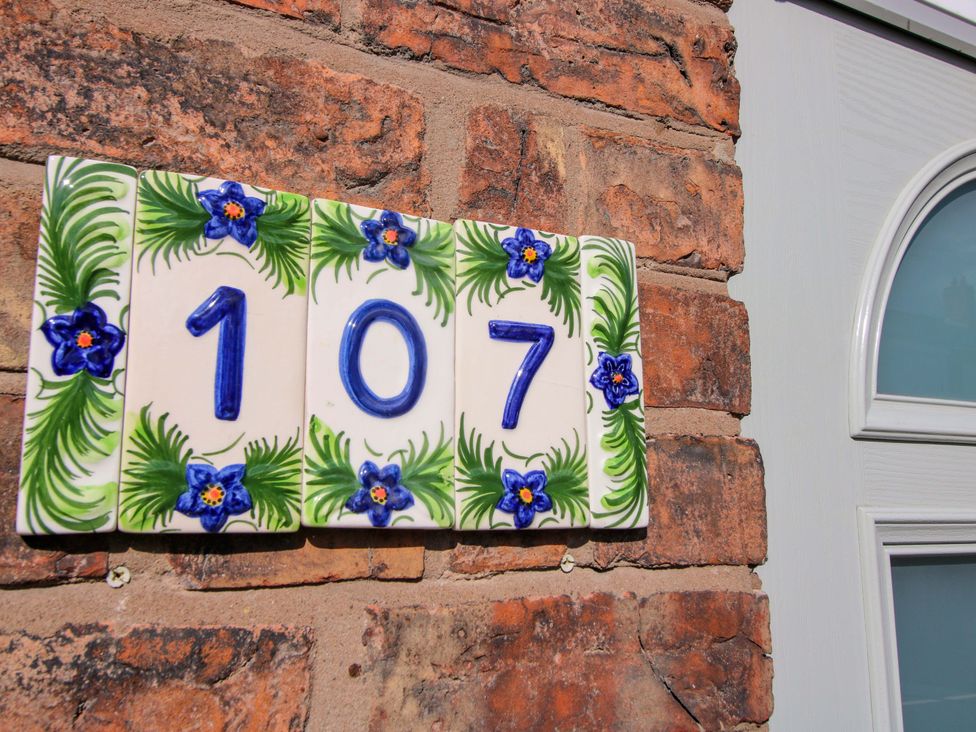 A decorative number plate on a brick wall at Riverside Cottage in Shrewsbury