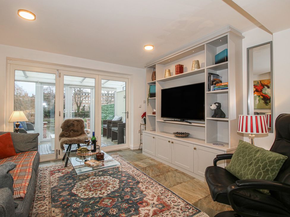 A living room with a sofa and television at Riverside Cottage in Shrewsbury