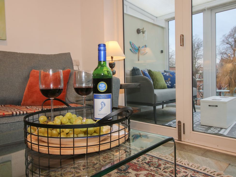 A living room with wine and grapes at Riverside Cottage in Shrewsbury