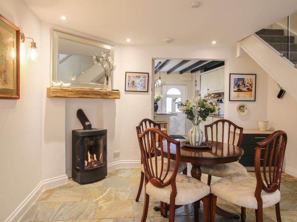 A dining room with a round table and chairs at Riverside Cottage in Shrewsbury