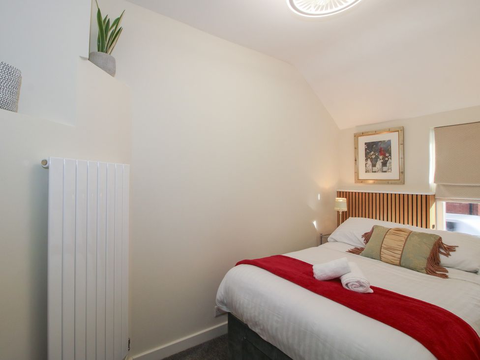 A bedroom with a bed and a framed artwork at Riverside Cottage in Shrewsbury