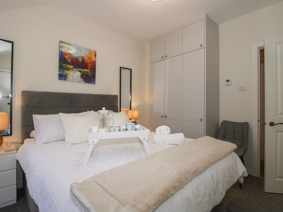 A bedroom with a bed and wardrobe at Riverside Cottage in Shrewsbury