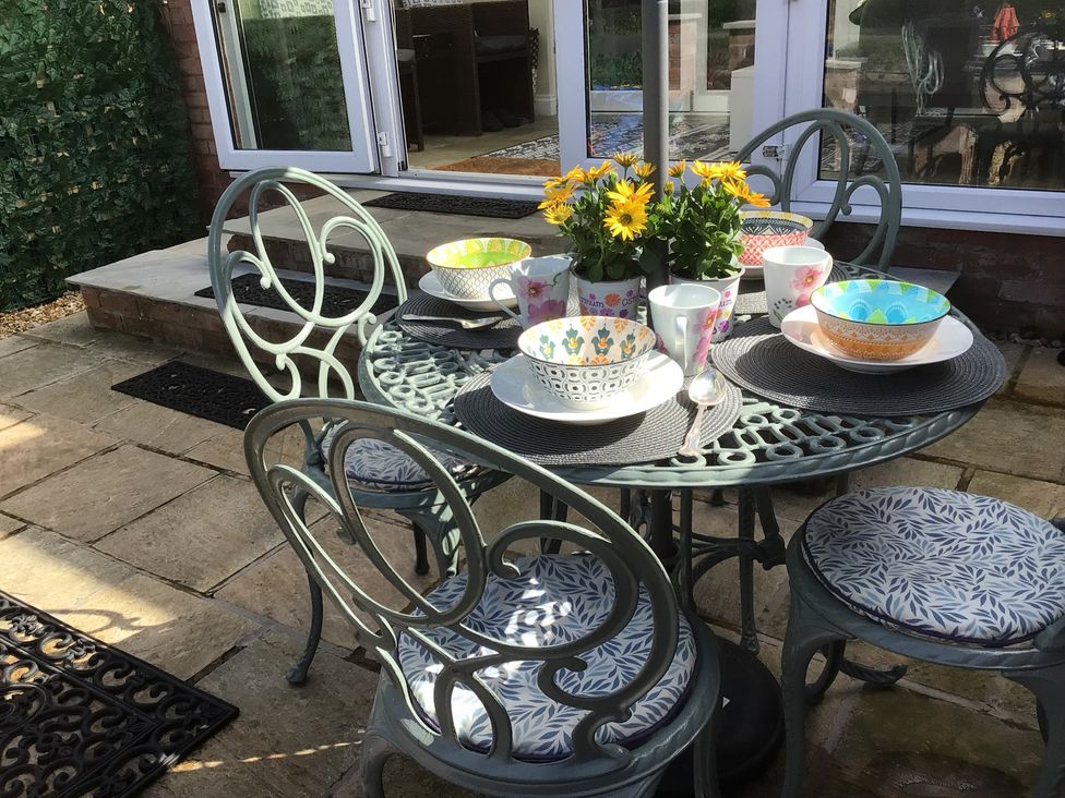 A dining area with a table set with bowls and cups at Riverside Cottage Shrewsbury