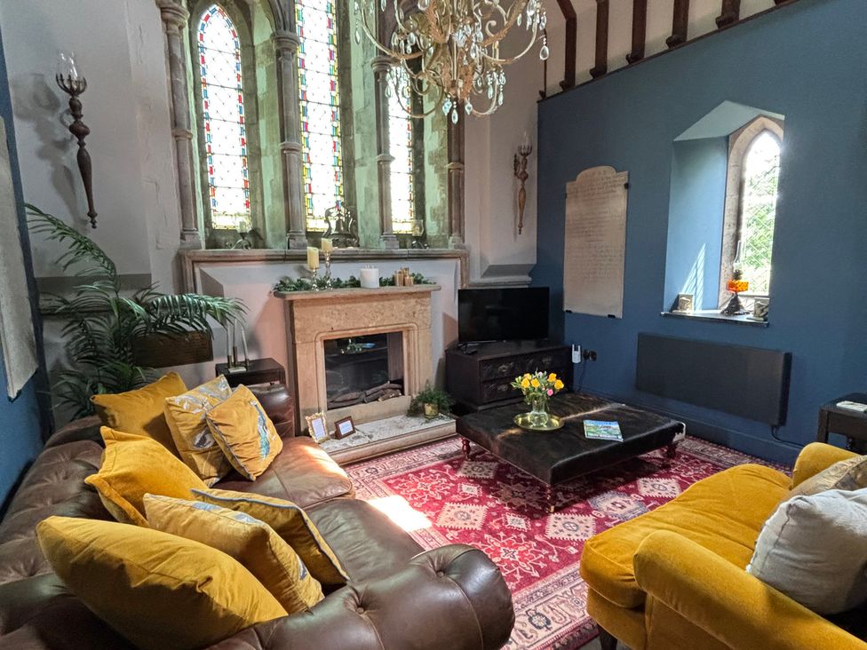 A living room with a fireplace and sofa at St Edmunds Church in Fraisthorpe
