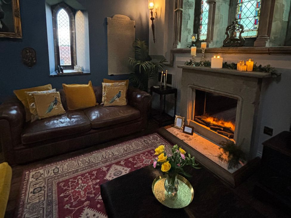 A living room with a sofa and fireplace at St Edmunds Church in Fraisthorpe