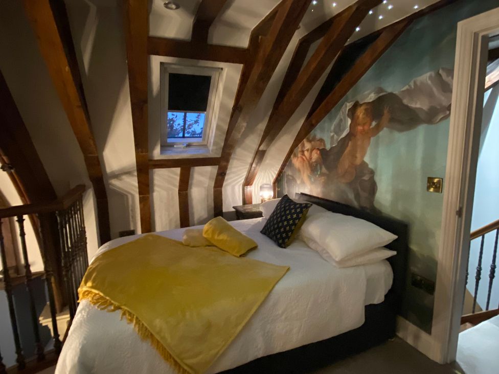 A bedroom with a bed and wall mural at St Edmunds Church in Fraisthorpe