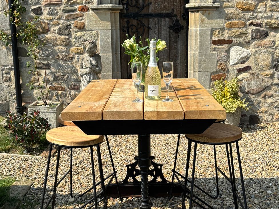 An outdoor dining area with a table and stools at St Edmunds Church in Fraisthorpe