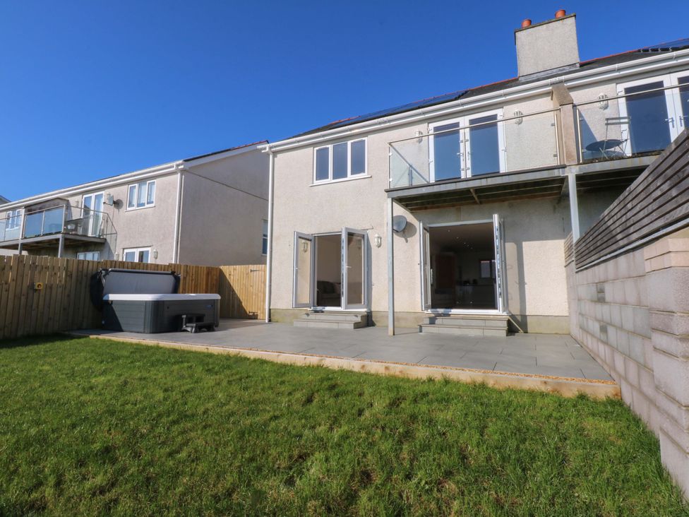 A house with a patio and hot tub at 15 Llys Tegeirian, Llangristiolus near Llangefni