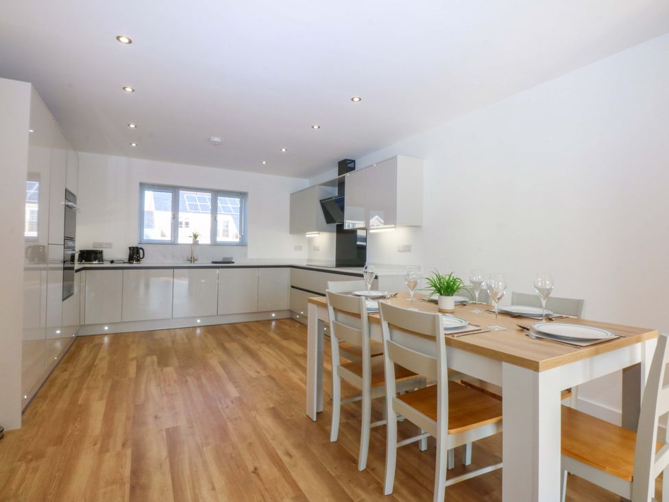 A kitchen with a dining table and chairs at 15 Llys Tegeirian Llangristiolus near Llangefni