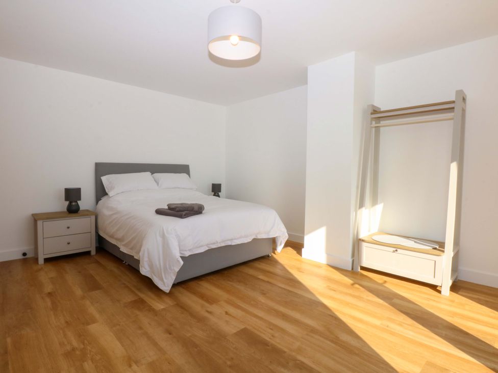 A bedroom with a bed and nightstand at 15 Llys Tegeirian in Llangristiolus near Llangefni