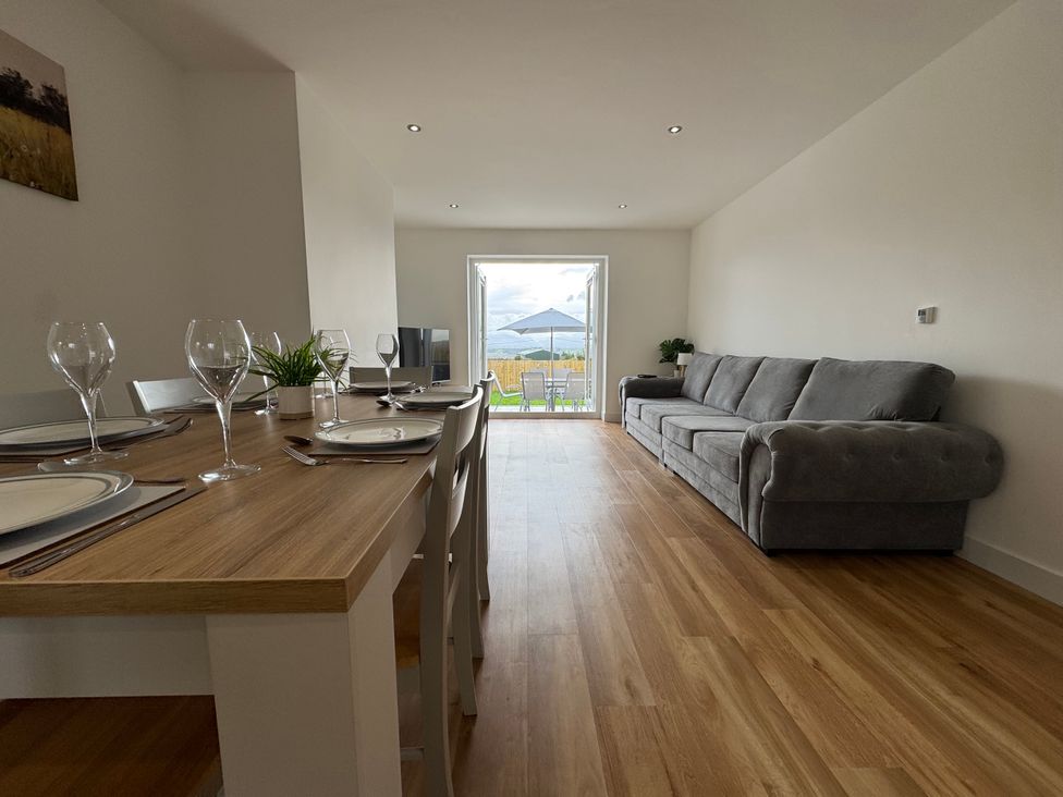 A dining room with a table and chairs at Golygfa in Llangristiolus near Llangefni