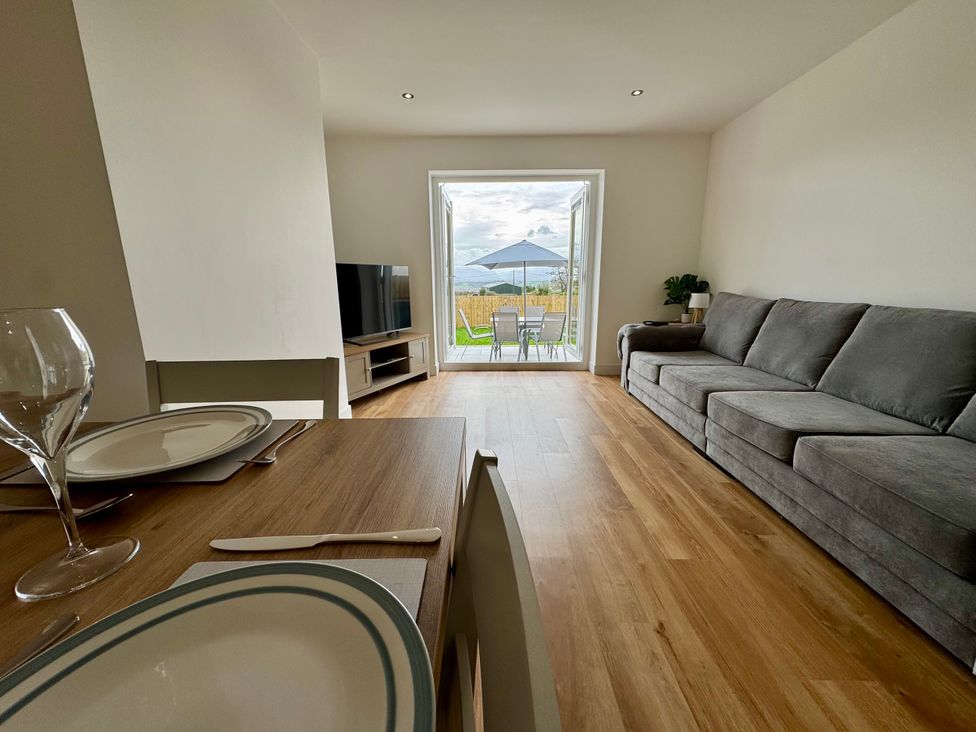 A living room with a sofa and television at Golygfa in Llangristiolus near Llangefni