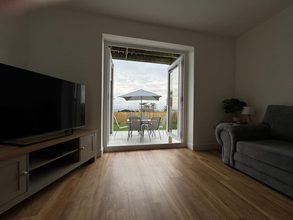 A living room with a television and sofa at Golygfa in Llangristiolus near Llangefni