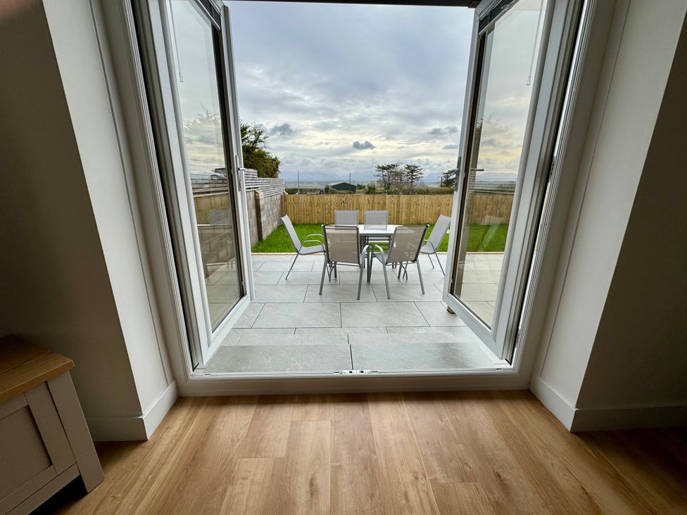A view of a patio with an outdoor table and chairs at Golygfa in Llangristiolus near Llangefni