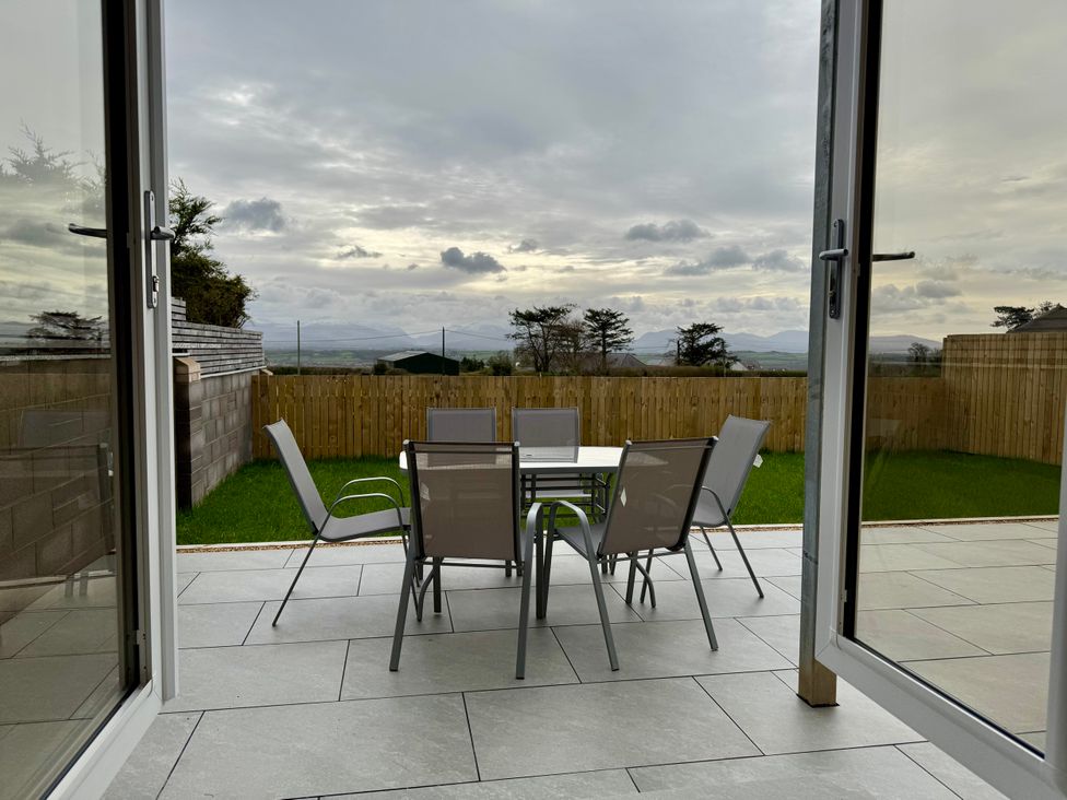 A garden with a table and chairs at Golygfa in Llangristiolus near Llangefni