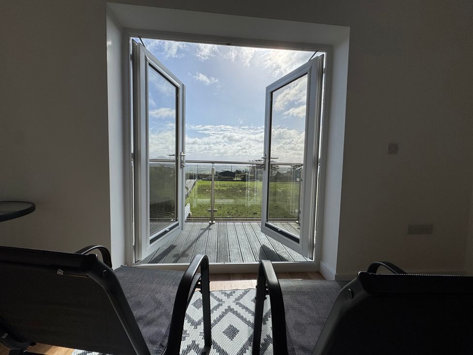A living room with a view of a balcony at Golygfa Llangristiolus near Llangefni