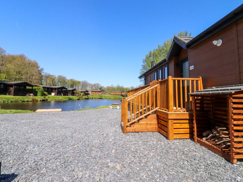 An outdoor view of a lodge by the water at Lakeview Lodge Forton near Garstang