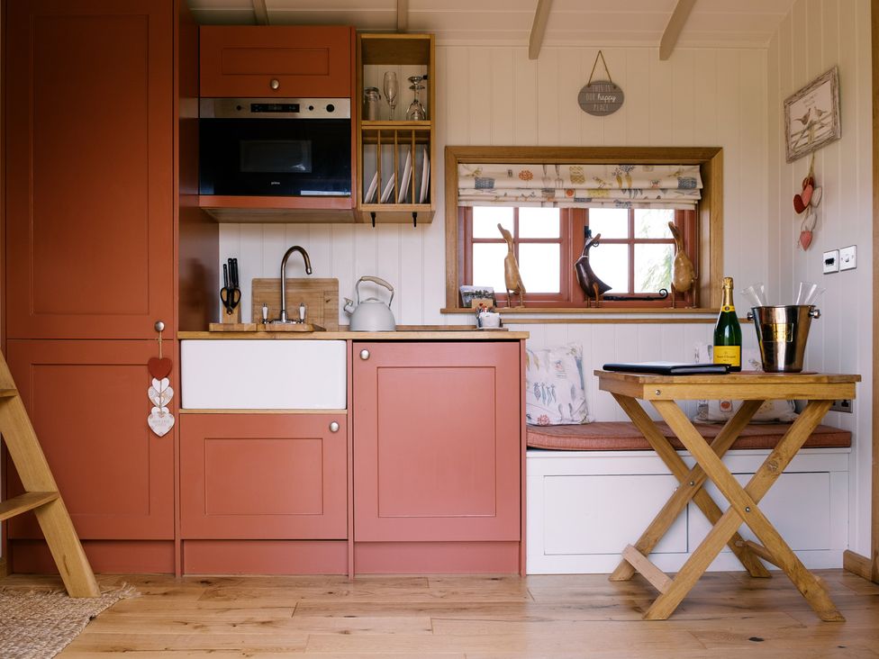 A kitchen with a sink and table at Bonnie's Shepherds Hut at Shepherds Lodge Retreat and Wellness Bottesford near Redmile and Vale of Belvoir