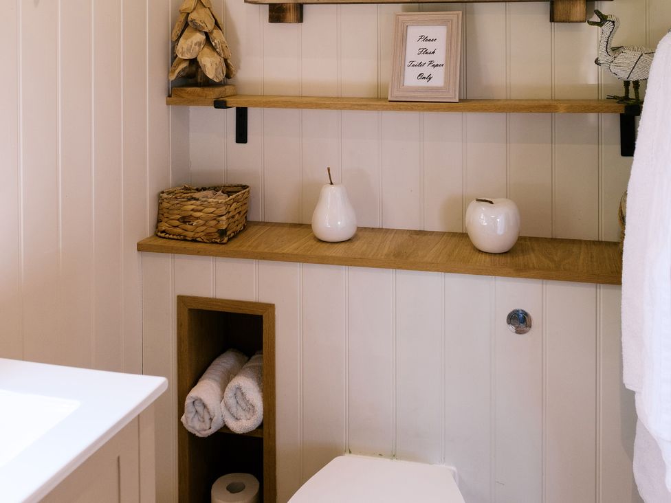 A bathroom with a toilet and shelves at Bonnie's Shepherds Hut at Shepherds Lodge Retreat and Wellness Bottesford near Redmile and Vale of Belvoir