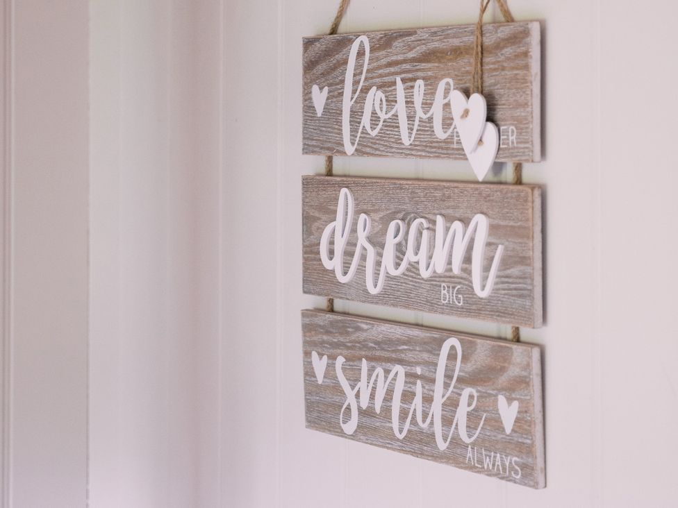 A wooden sign with text hanging on a wall at Bonnie's Shepherds Hut at Shepherds Lodge Retreat and Wellness in Bottesford near Redmile and Vale of Belvoir
