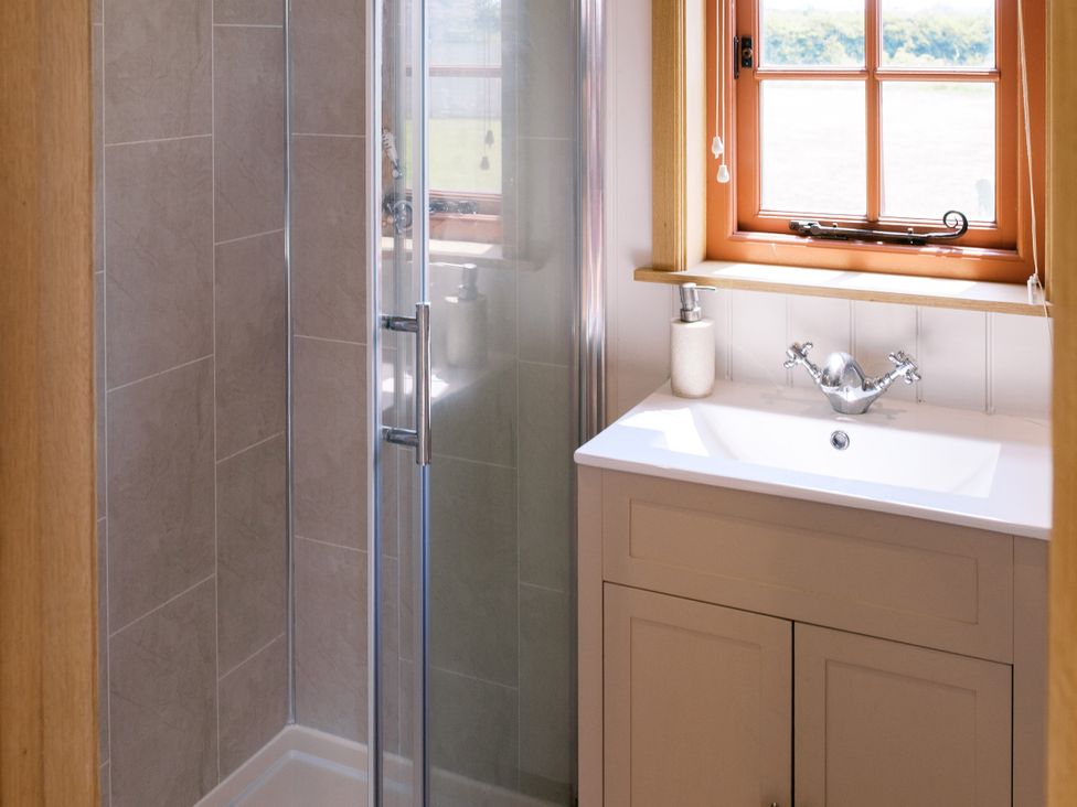 A bathroom with a shower and sink at Bonnie's Shepherds Hut at Shepherds Lodge Retreat and Wellness, Bottesford near Redmile and Vale of Belvoir