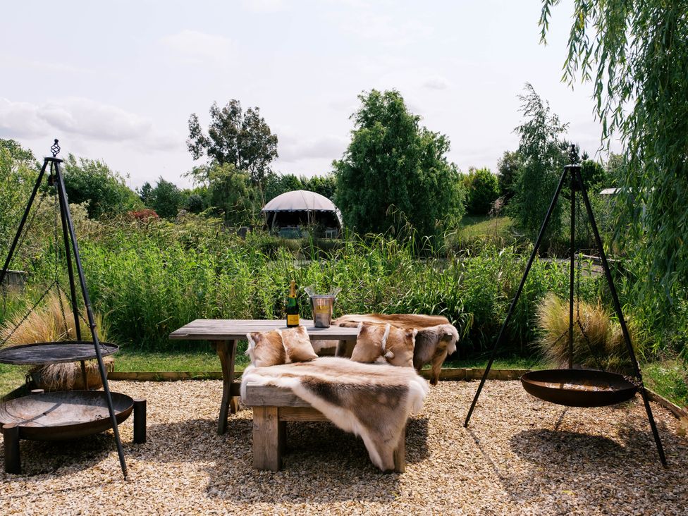 An outdoor seating area with table and chairs at Bonnie's Shepherds Hut at Shepherds Lodge Retreat and Wellness Bottesford near Redmile and Vale of Belvoir
