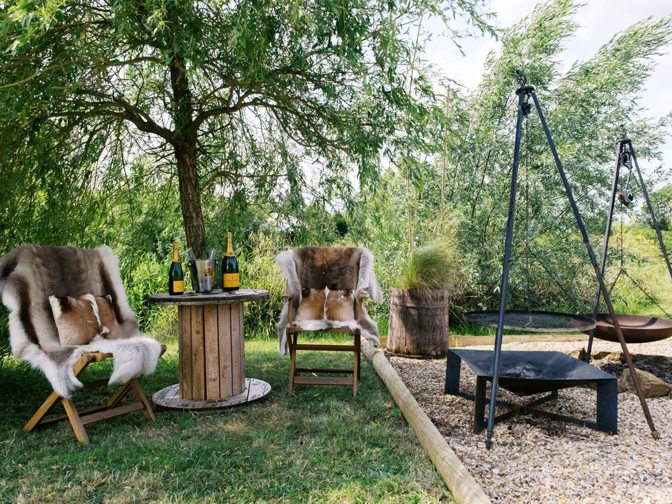 An outdoor area with chairs, a table, and a fire pit at Bonnie's Shepherds Hut at Shepherds Lodge Retreat and Wellness near Bottesford