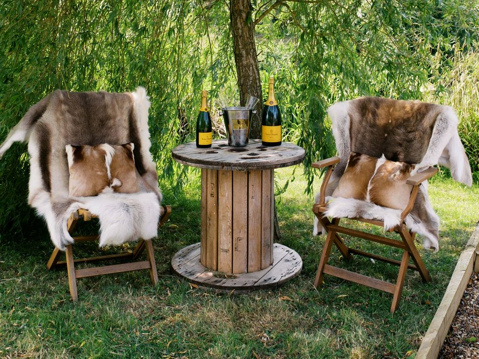 An outdoor seating area with two chairs and a table at Bonnie's Shepherds Hut at Shepherds Lodge Retreat and Wellness Bottesford near Redmile and Vale of Belvoir