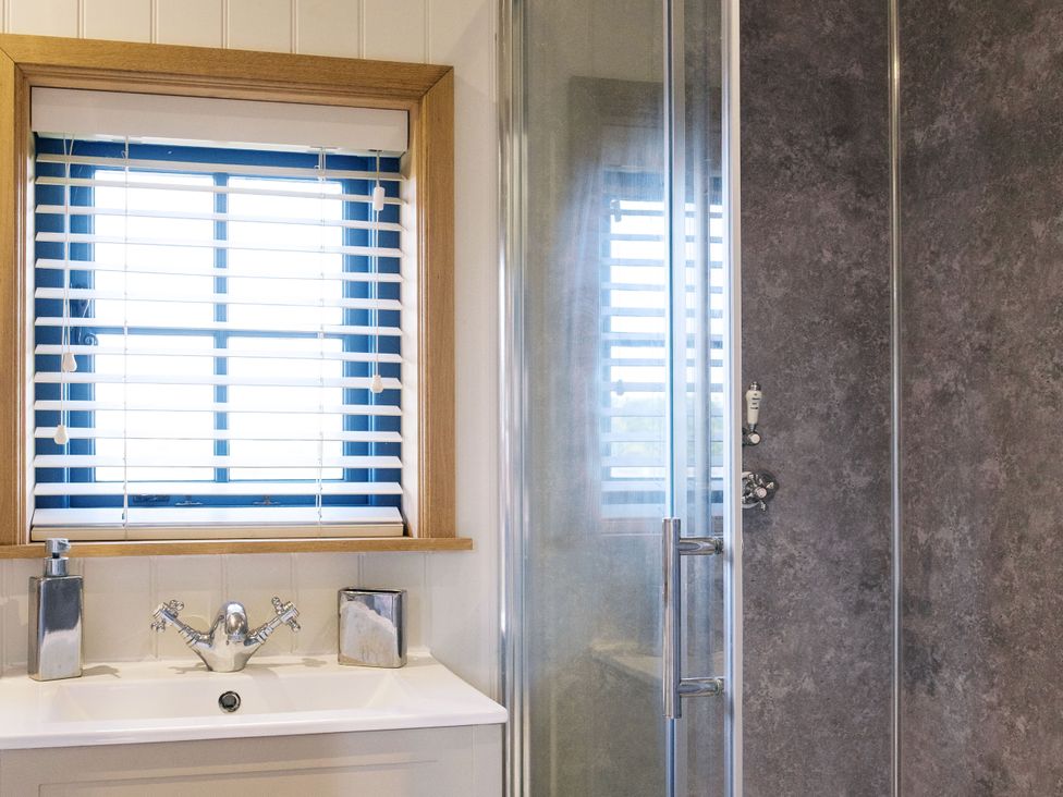 A bathroom with a sink and shower at Lillie's Shepherds Hut at Shepherds Lodge Retreat and Wellness Bottesford near Redmile and Vale of Belvoir