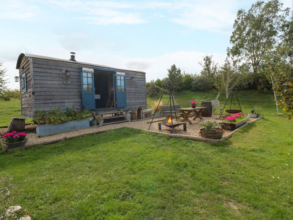 An outdoor area with a shepherd's hut and seating at Lillie's Shepherds Hut at Shepherds Lodge Retreat and Wellness Bottesford near Redmile and Vale of Belvoir