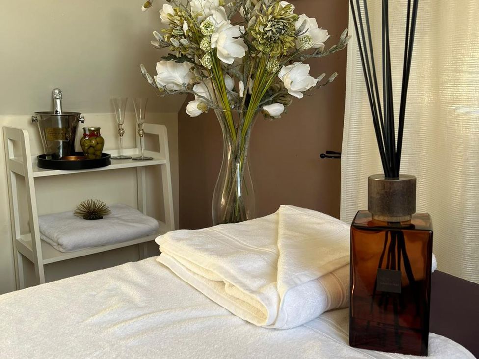 A spa room with towels and a vase of flowers at Lillie's Shepherds Hut at Shepherds Lodge Retreat and Wellness Bottesford near Redmile and Vale of Belvoir