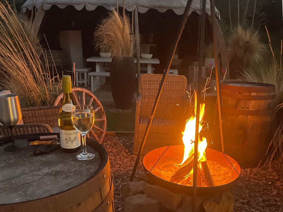 An outdoor space with a fire pit and wine at Lillie's Shepherds Hut at Shepherds Lodge Retreat and Wellness Bottesford near Redmile and Vale of Belvoir