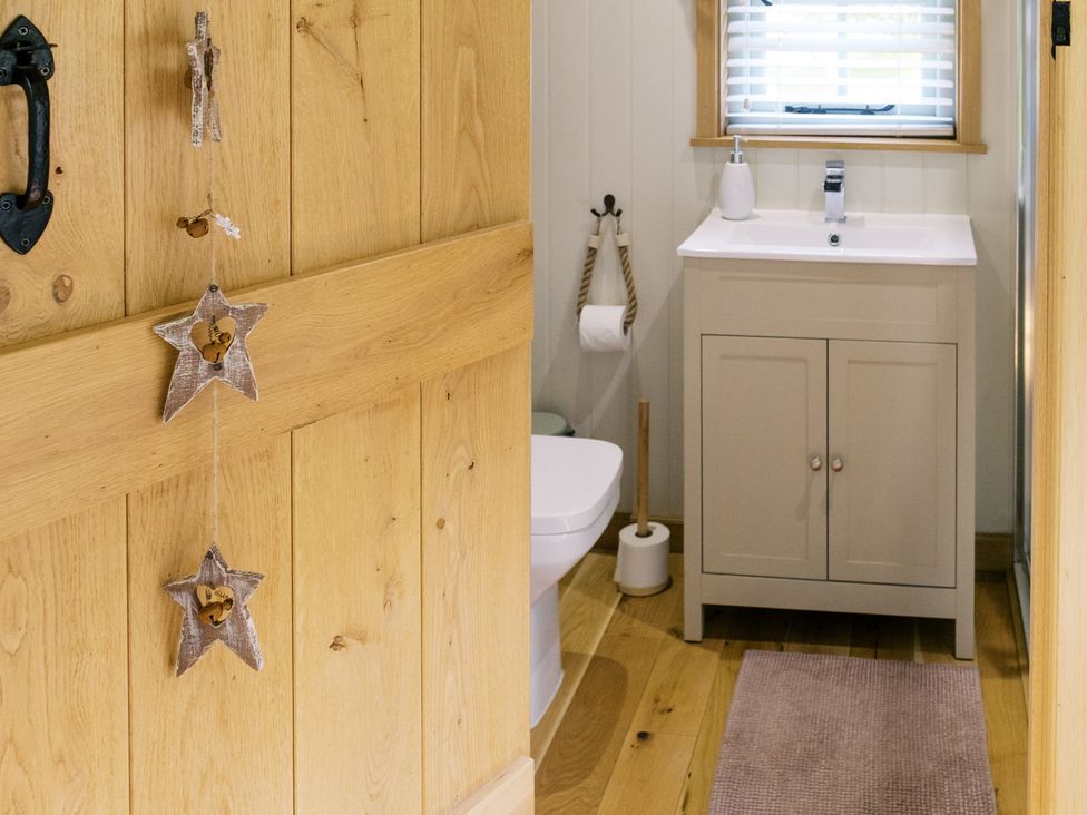 A bathroom with a sink and toilet at Herbie's Shepherds Hut at Shepherds Lodge Retreat and Wellness Bottesford near Redmile and Vale of Belvoir