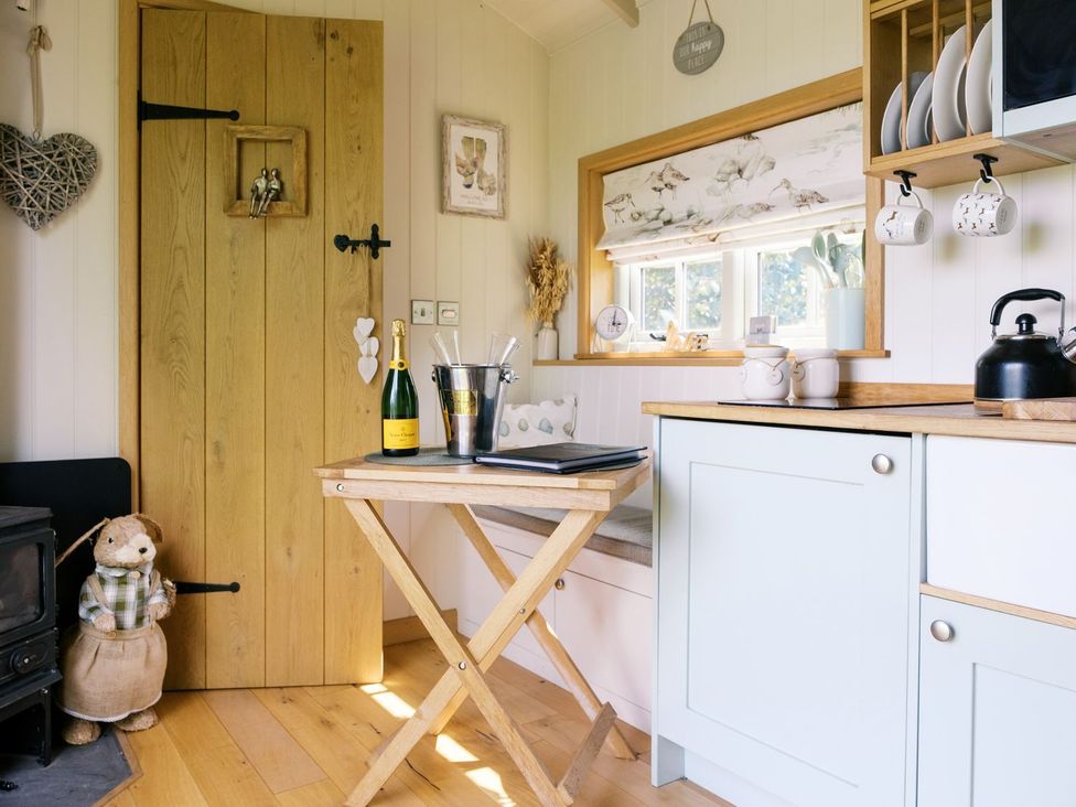 A kitchen with a table and champagne at Herbie's Shepherds Hut at Shepherds Lodge Retreat and Wellness Bottesford near Redmile and Vale of Belvoir