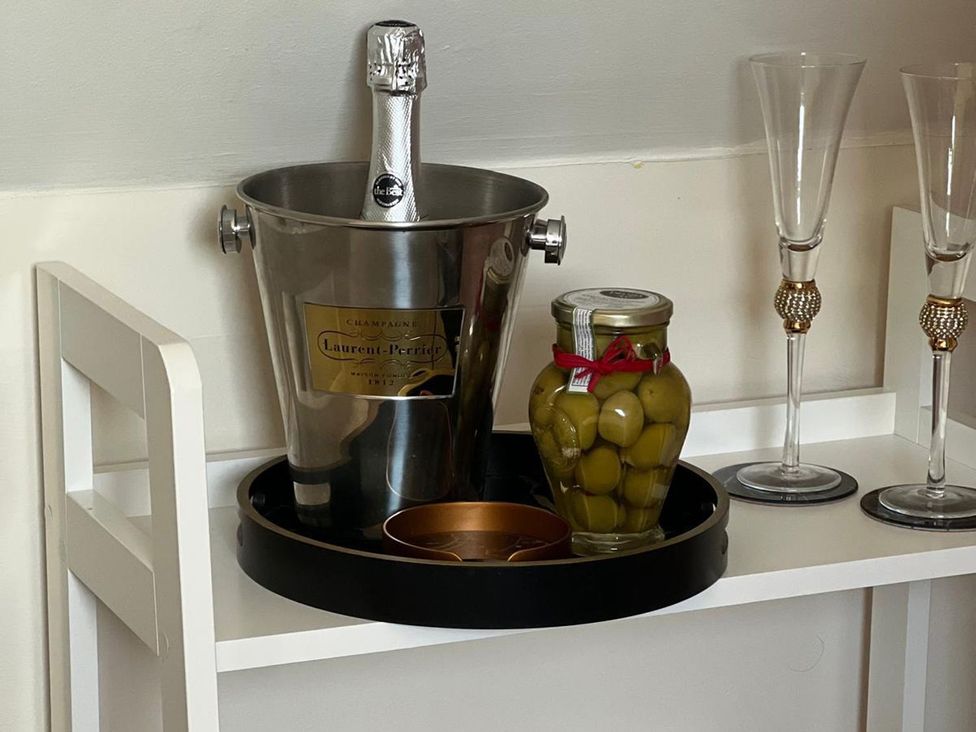 A champagne bottle and glasses on a tray at Herbie's Shepherds Hut at Shepherds Lodge Retreat and Wellness Bottesford near Redmile and Vale of Belvoir