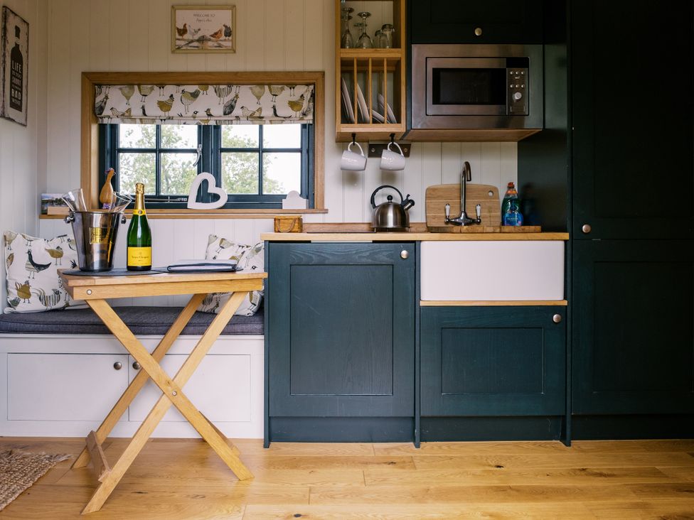 A kitchen with a table and sink at Poppie's Shepherds Hut at Shepherds Lodge Retreat and Wellness Bottesford near Redmile and Vale of Belvoir