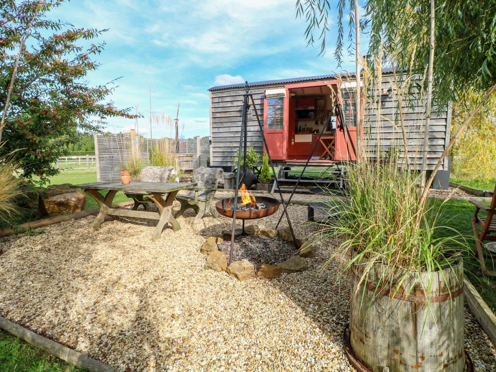 A garden with a fire pit and outdoor furniture at Poppie's Shepherds Hut at Shepherds Lodge Retreat and Wellness in Bottesford near Redmile and Vale of Belvoir