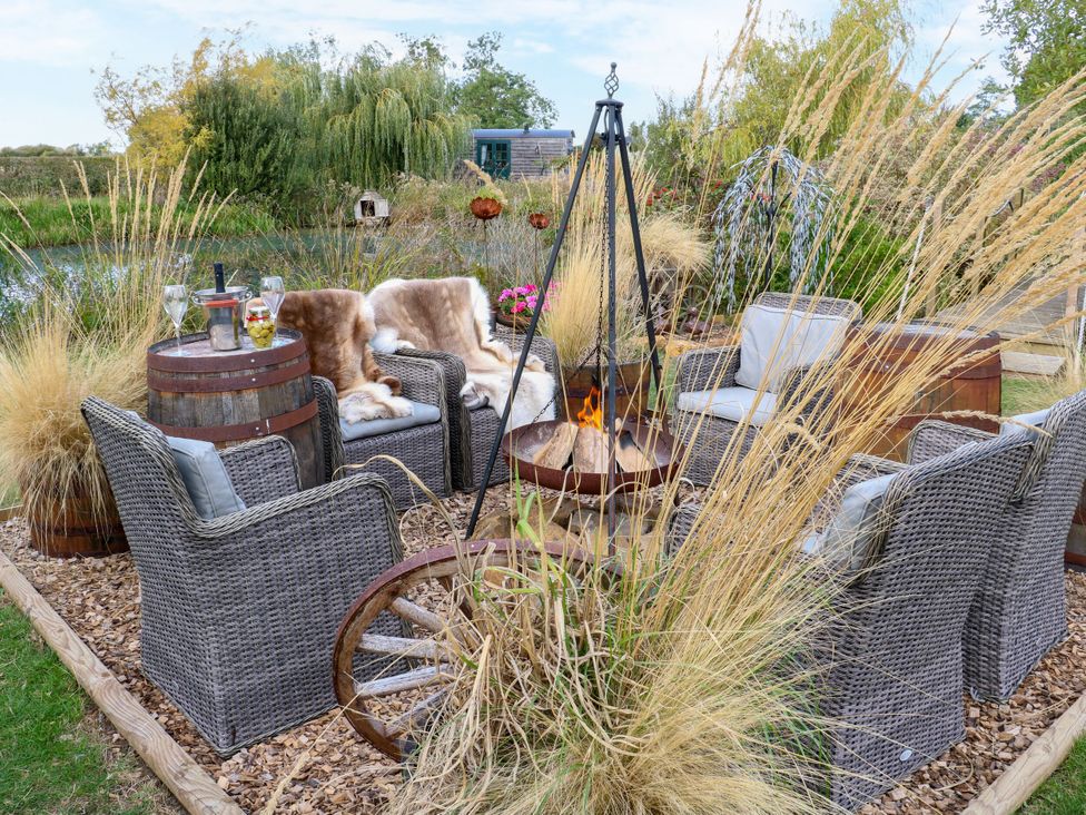 An outdoor seating area with chairs and a fire pit at Poppie's Shepherds Hut at Shepherds Lodge Retreat and Wellness, Bottesford near Redmile and Vale of Belvoir