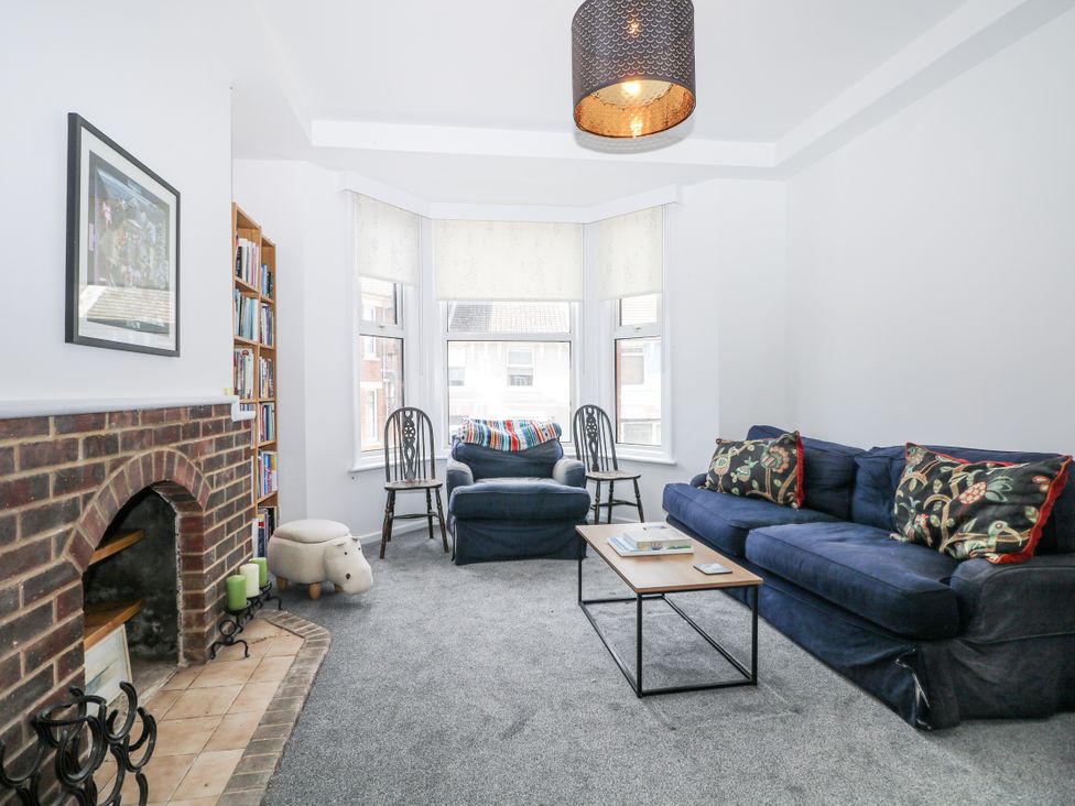 A living room with a sofa, armchair, and bookshelf at 108 Emmanuel Road, Hastings