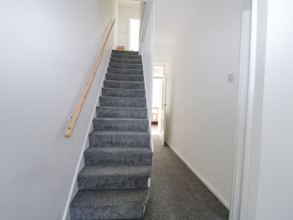 A hallway with stairs and a doorway at 108 Emmanuel Road in Hastings