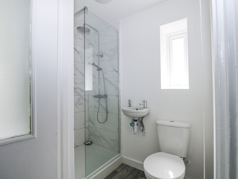 A bathroom with a shower, toilet, and sink at 108 Emmanuel Road in Hastings