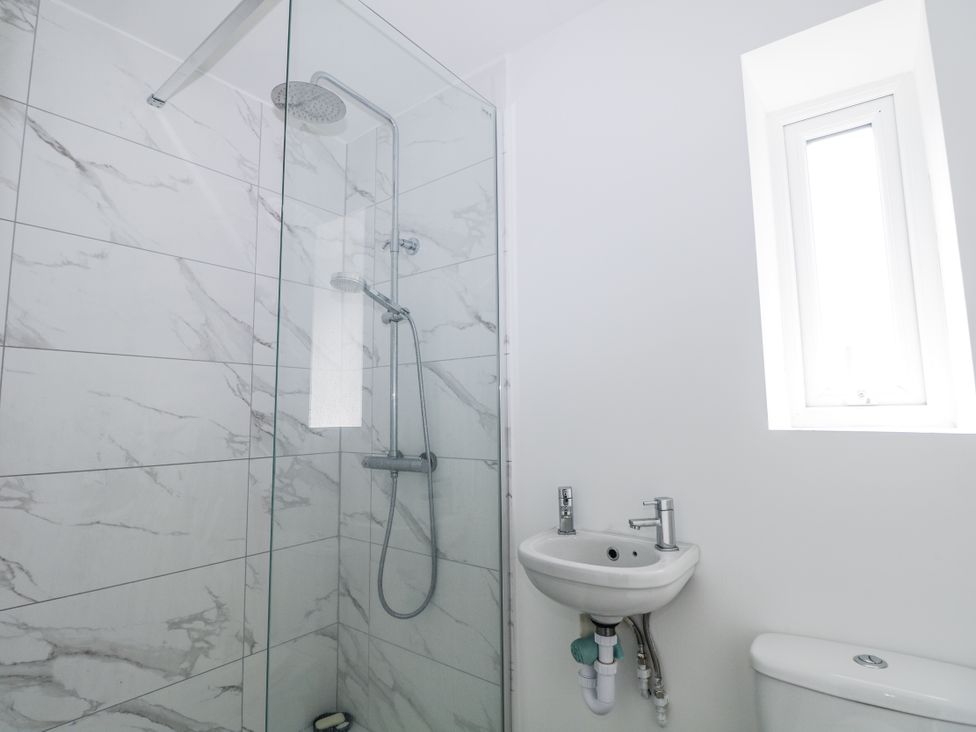 A bathroom with a shower, sink, and toilet at 108 Emmanuel Road in Hastings