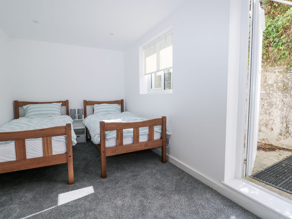 A bedroom with two beds and a window at 108 Emmanuel Road in Hastings