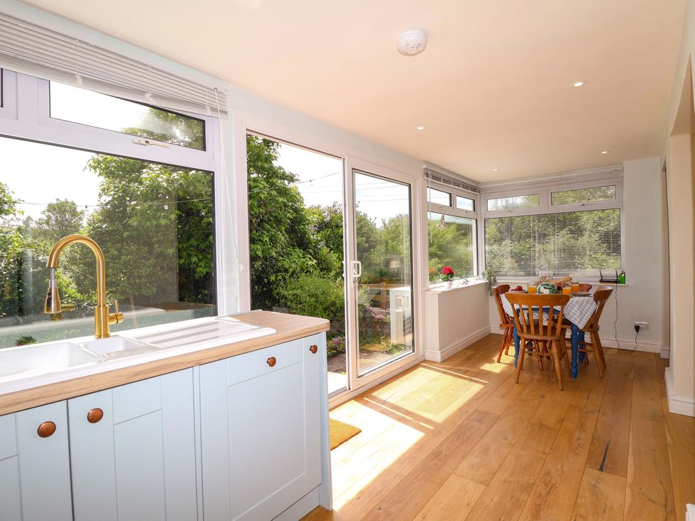 A kitchen with a sink and dining table at Walnut Major in Kingsbridge