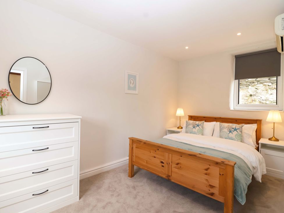 A bedroom with a bed and dresser at Walnut Major Kingsbridge