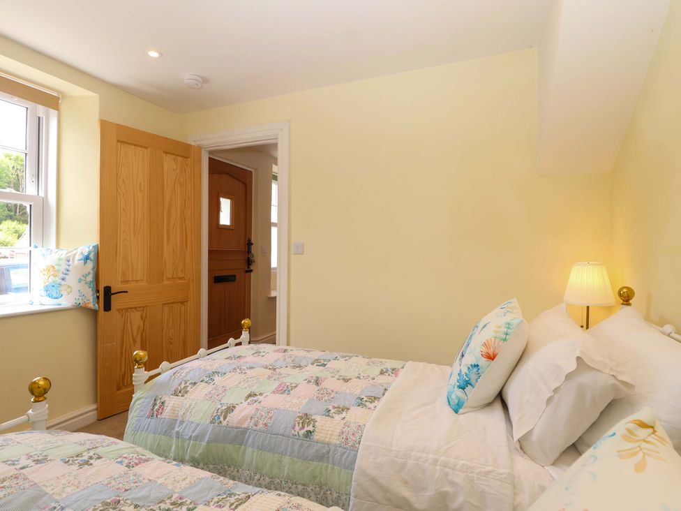 A bedroom with two beds and a window at Walnut Major in Kingsbridge