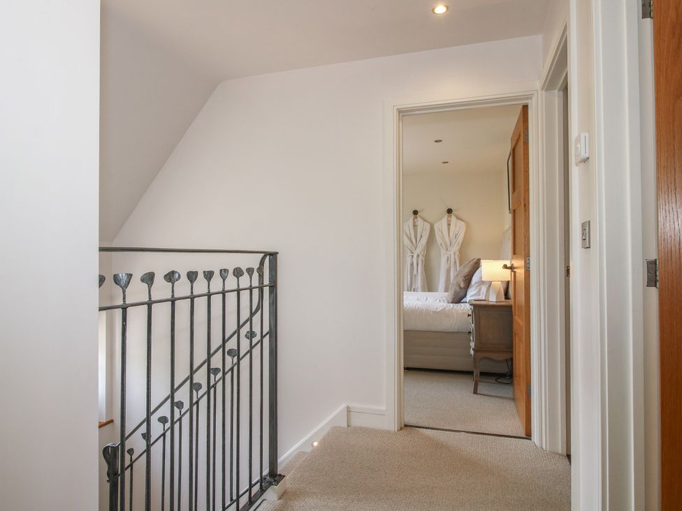 A hallway with a stair railing and a door leading to a bedroom at White House in Montgomery