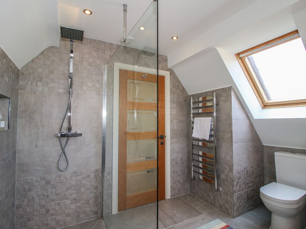 A bathroom with a shower, toilet, and towel rack at White House in Montgomery
