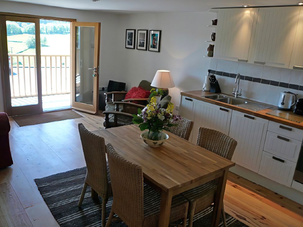 A living room with a dining table and kitchen area at Cottage 1 in Presteigne